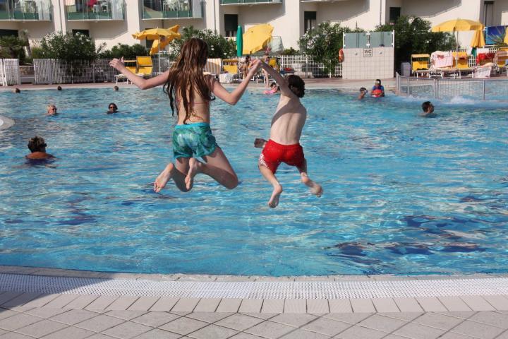 Kinder springen in den Pool des Hotel Maregolf in Caorle, Atanea, Italien