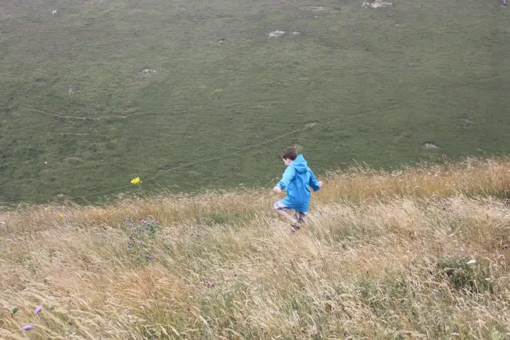 Kleiner Junge rennt über die Weise bei der Schlucht Devil's Dyke