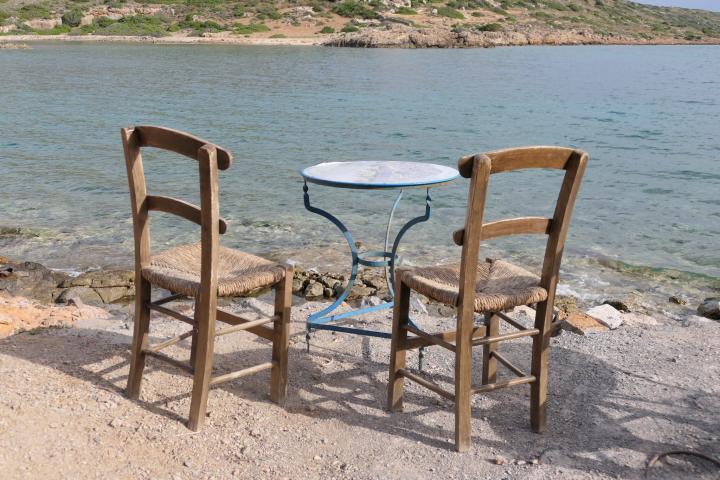 Tisch und Stühle direkt am Meer auf Spinalonga, Kreta